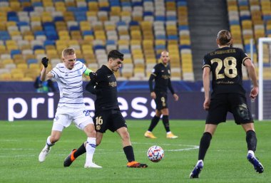 KYIV, UKRAINE - NOVEMBER 24, 2020: Dinamo Kyiv 'li Vitaliy Buyalskiy (L), NSC Olimpiyskyi stadyumunda oynanan UEFA Şampiyonlar Ligi maçı sırasında Barselonalı Pedri ile bir top için mücadele etmektedir. Barcelona 4-0 kazandı.
