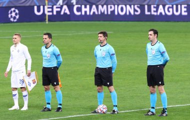KYIV, UKRAINE - NOVEMBER 24, 2020: Hakem Matej Jug (SVN) ve asistanlar Matej Zuniç ve Robert Vukan, UEFA Şampiyonlar Ligi maçı Dynamo Kyiv Barcelona 'nın önünde sahada durdular