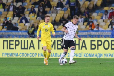 KYIV, UKRAINE - 10 Ekim 2020: Ukraynalı Viktor Tsygankov, NSK Olimpiyskiy Stadyumu 'nda oynanan UEFA Uluslar Ligi maçı sırasında Almanya' dan Matthias Ginter ile top için mücadele etmektedir. Almanya 2-1 kazandı.