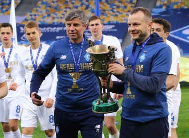 KYIV, UKRAINE - 25 Nisan 2021: FC Dynamo Kyiv asistan antrenörleri Emilian Karas (L) ve Oleh Husiev, Ukrayna Premier Ligi 2020-21 sezonunu NSC Olimpiyskiy Stadyumu 'nda kazananlarla birlikte poz verdiler.