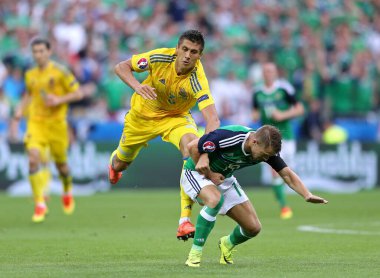 LYON, FRANCE - 16 Haziran 2016: Ukraynalı Yevhen Khacheridi, Kuzey İrlandalı Jamie Ward ile Stade de Lyon Stadyumu 'nda oynanan 2016 UEFA maçı sırasında top için mücadele etmektedir. N.Ireland 2-0 kazandı.