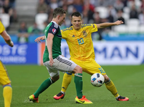 LYON, FRANCE - 16 Haziran 2016: Kuzey İrlandalı Corry Evans (L), Ukraynalı Yevhen Konoplyanka ile Stade de Lyon Stadyumu 'nda oynanan 2016 UEFA EURO maçı sırasında top için mücadele etmektedir. N.Ireland 2-0 kazandı.