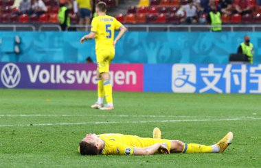 BÜKREŞ, ROMANIA - 21 Haziran 2021: Ukraynalı Roman Yaremchuk, UEFA EURO 2020 maçından sonra Milli Arena Bükreş Stadyumu 'nda Avusturya' ya karşı oynanan maçın ardından çimlerin üzerinde yatmaktadır. Avusturya 1-0 kazandı