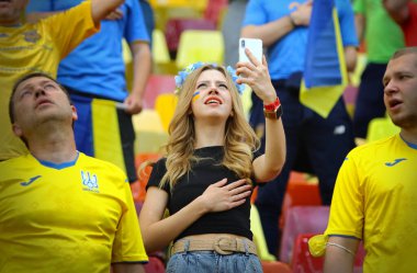 BÜKREŞ, ROMANIA - 21 Haziran 2021: Ukrayna futbol taraftarı UEFA EURO 2020 Ukrayna maçı öncesinde Ukrayna Milli Marşını söylüyor