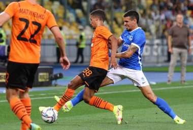 KYIV, UKRAINE - 10 AĞUSTOS 2021: Shakhtar Donetsk 'li Pedrinho (L) UEFA Şampiyonlar Ligi üçüncü tur elemeleri sırasında Genk' li Daniel Munoz ile top için mücadele eder. Shakhtar 2-1 kazandı.