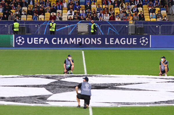 KYIV, UKRAINE - SEPTEMBER 14,2021: Pitch of NSK Olimpiyskiy stadium with UEFA Champions League official logo in centre circle and billboard seen during UEFA Champions League game Dynamo Kyiv v Benfica