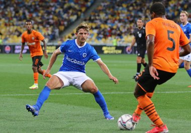 KYIV, UKRAINE - 10 AĞUSTOS 2021: Genk (L) takımlarından Patrik Hrosovsky, UEFA Şampiyonlar Ligi üçüncü tur eleme maçı sırasında Shakhtar Donetsk 'li Marlon ile top için mücadele eder. Shakhtar 2-1 kazandı.