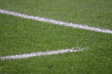 Yeşil futbol sahası üzerinde beyaz şeritler