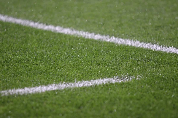 Белые полосы на зеленом футбольном поле — стоковое фото