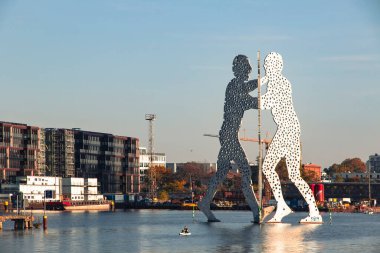 Berlin, Almanya - 20 Ekim 2025: Molekül Adam Spree nehri üzerinde heykel. Jonathan Borofsky 'nin 30 metrelik ikonik çelik heykeli (1999) Doğu ve Batı Almanya' yı birleştiren Almanya