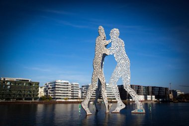 Berlin, Almanya - 20 Ekim 2025: Molekül Adam Spree nehri üzerinde heykel. Jonathan Borofsky 'nin 30 metrelik ikonik çelik heykeli (1999) Doğu ve Batı Almanya' yı birleştiren Almanya