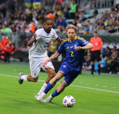 Wroclaw, Polonya - 5 Eylül 2025: Ukraynalı Yukhym Konoplia (R), Wroclaw 'daki Tarczynski Arena' da oynanan 2026 FIFA Dünya Kupası elemeleri sırasında Fransız Bradley Barcola ile top için mücadele ediyor.