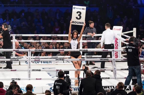 Anillo de boxeo chicas sosteniendo un tablero con número redondo — Foto de Stock