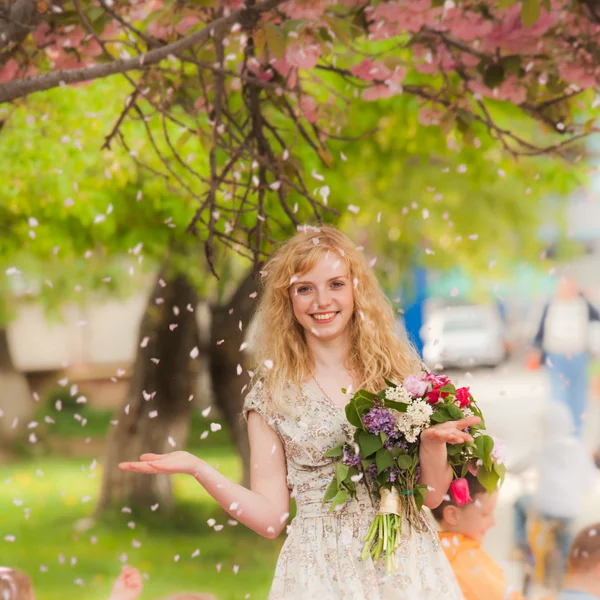 Ragazza sorridente sotto fiori di sakura — Foto Stock