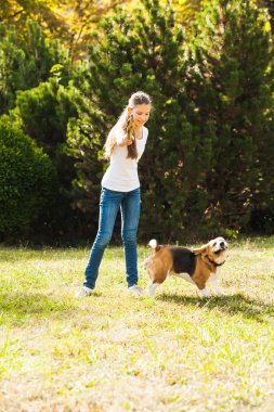 Kız bahçede bir köpekle oynar