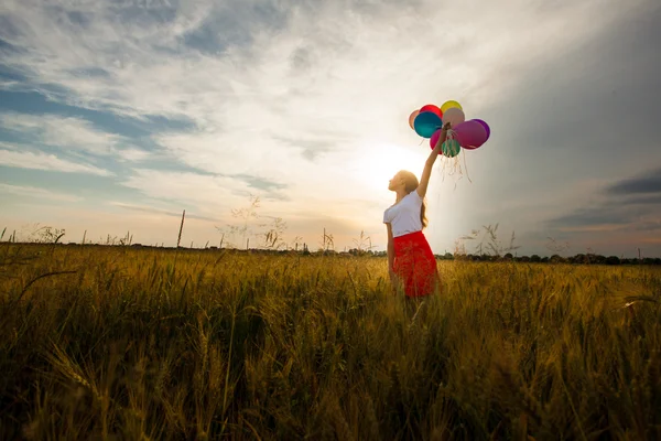 Chica con globos en el campo de trigo —  Fotos de Stock