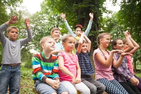 Grupo de niños en un banco del parque — Foto de Stock