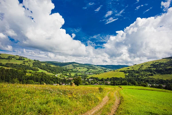 Špinavá cesta do malebné horské vesnice — Stock fotografie