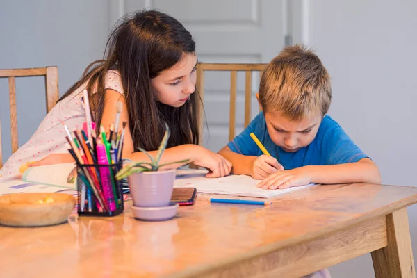 Sister assisting brother to study at home — Stock Photo, Image