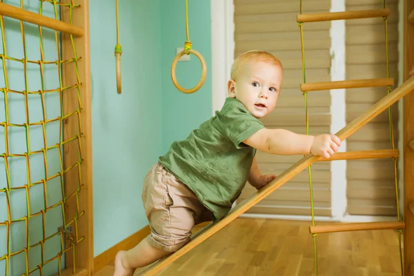 Μικρό αγόρι αναρρίχηση σε εσωτερική ξύλινη διαφάνεια — Φωτογραφία Αρχείου