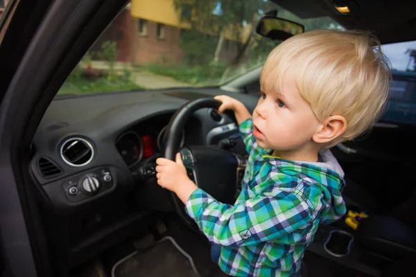 El chico se imagina a sí mismo como un conductor en un coche real —  Fotos de Stock