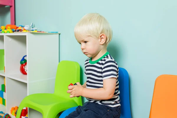 El niño abandonado por todos está sentado en la sala de juegos. — Foto de Stock