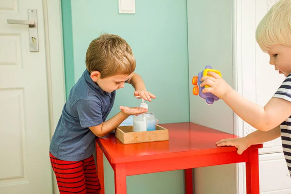 Der kleine Junge benutzt Antiseptikum, bevor er in den Kindergarten kommt — Stockfoto