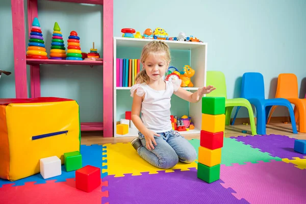 Das Mädchen baut im Spielzimmer einen Würfelturm — Stockfoto