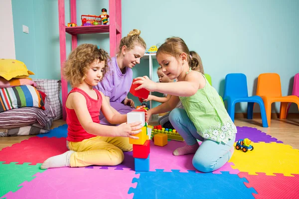 O grupo de meninas no jardim de infância está brincando com brinquedos — Fotografia de Stock