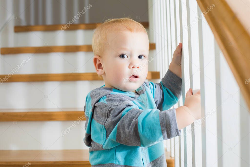 The baby carefully goes down the stairs at home