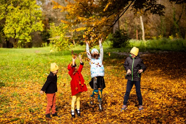 Дети любят играть с листьями в осенний сезон — стоковое фото