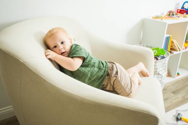 Annesinin en sevdiği rahat koltukta rahat oluyor.