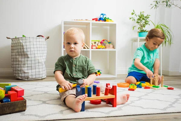 Niño pequeño y bebé juegan con juguetes educativos — Foto de Stock