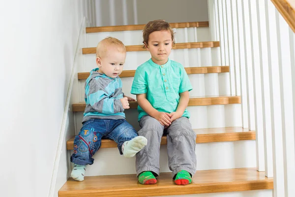 Два прекрасных брата сидят на деревянной лестнице — стоковое фото