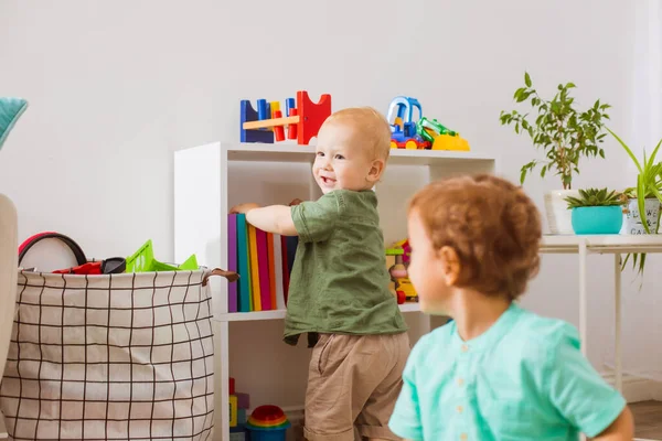 Двое малышей играют и развиваются в игровой комнате — стоковое фото