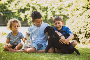Çocuklar dışarıda evcil hayvanlarla oynamayı severler.