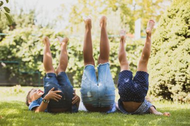 Küçük arkadaşlar çimenlere uzanır ve bacaklarını kaldırırlar.