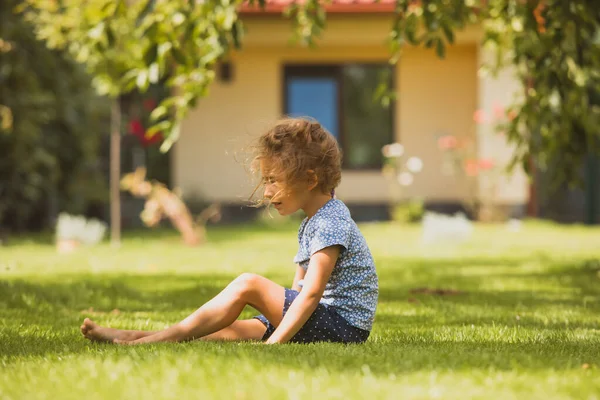 The lonely little girl in the backyard — Stock Photo, Image