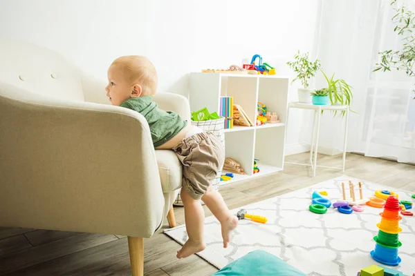 Petit garçon tenant serré au fauteuil enquêtant sur la surface — Photo