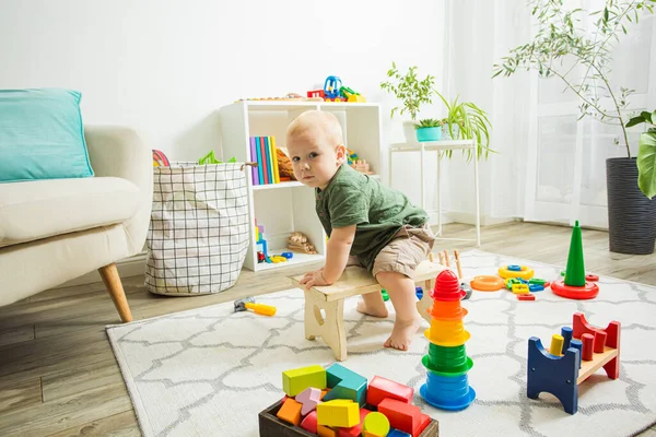 Jongen paardrijden kleine houten bank als een paard — Stockfoto