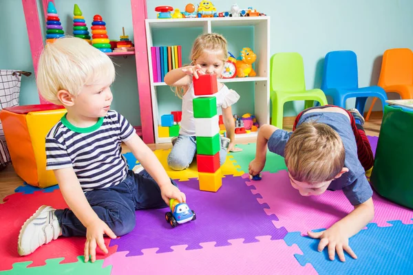 Дети играют с различными игрушками в игровой комнате — стоковое фото