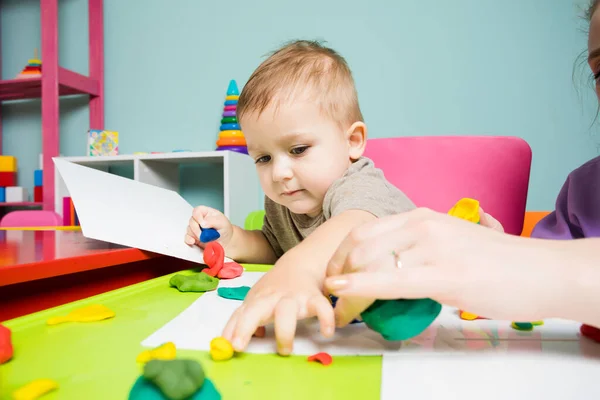 The toddler in art class is modeling clay — Photo