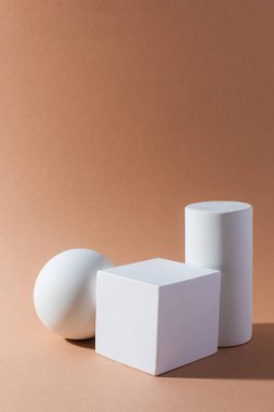 Açık kahverengi arkaplanda beyaz üç boyutlu geometrik şekiller