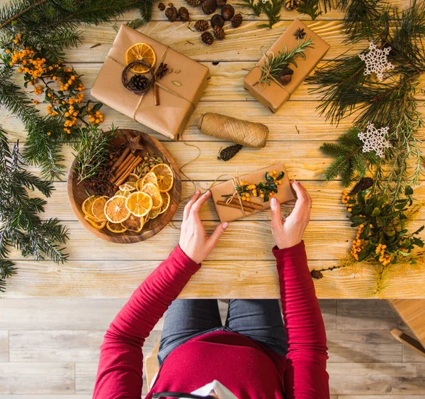 Masada bir kadın oturuyor. En iyi görüntü Noel hediyeleri — Stok fotoğraf