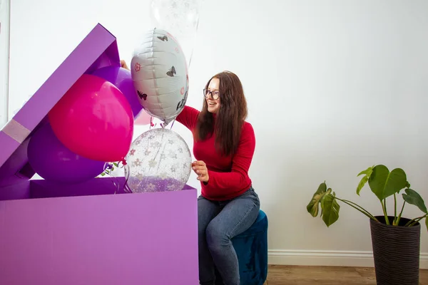 Het brunette meisje met grote verjaardag cadeau en ballonnen — Stockfoto