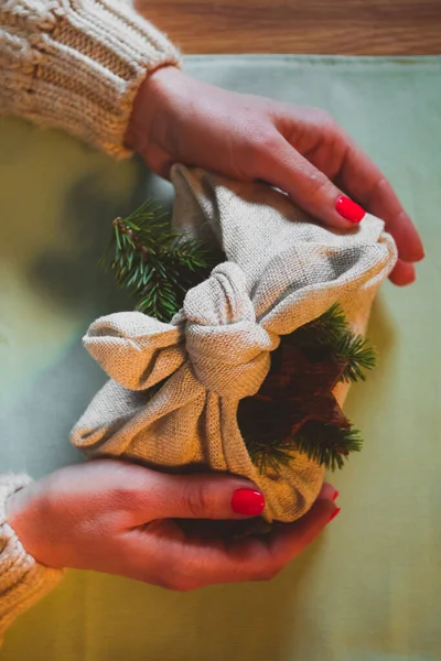 De vrouw houdt milieuvriendelijk cadeau Furoshiki vast. — Stockfoto