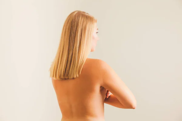 Vista posterior de la mujer joven en topless en bckground blanco — Foto de Stock