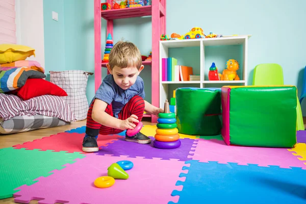 A criança saudável está se divertindo com pirâmide de brinquedos — Fotografia de Stock