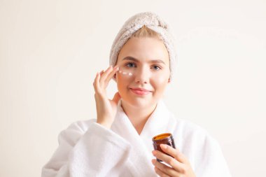 Canlandırıcı ve nemlendirici krem kullanan kız, beyaz arkaplan