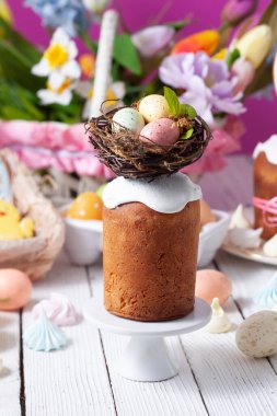 Yuvada renkli yumurtalarla süslenmiş paskalya pastası.